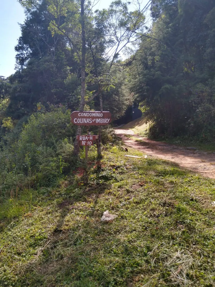 Placa de sinalização de madeira na estrada de chegada, indicando Rua H, nº 10